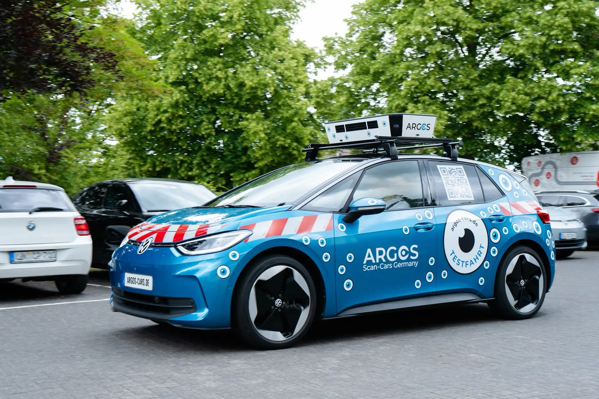 Blaues ARGOS Scan-Car mit Kameraaufbau auf dem Dach auf einem Parkplatz
