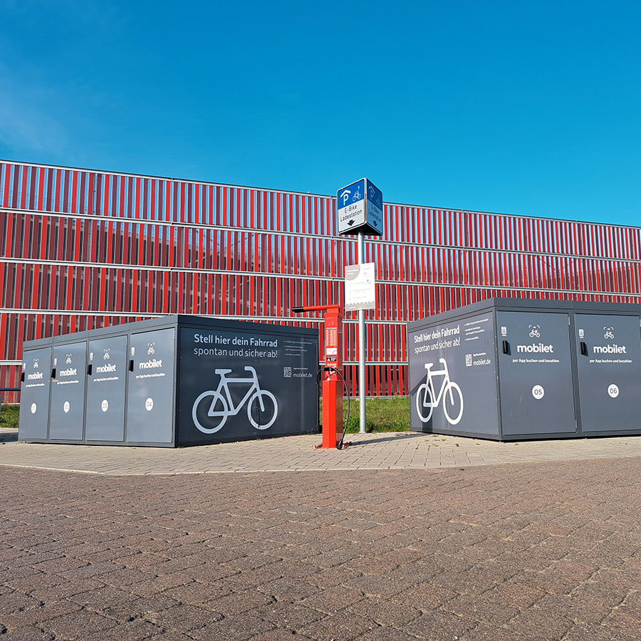 Fahrradboxen von mobilet stehen vor einem Parkhaus in Wismar