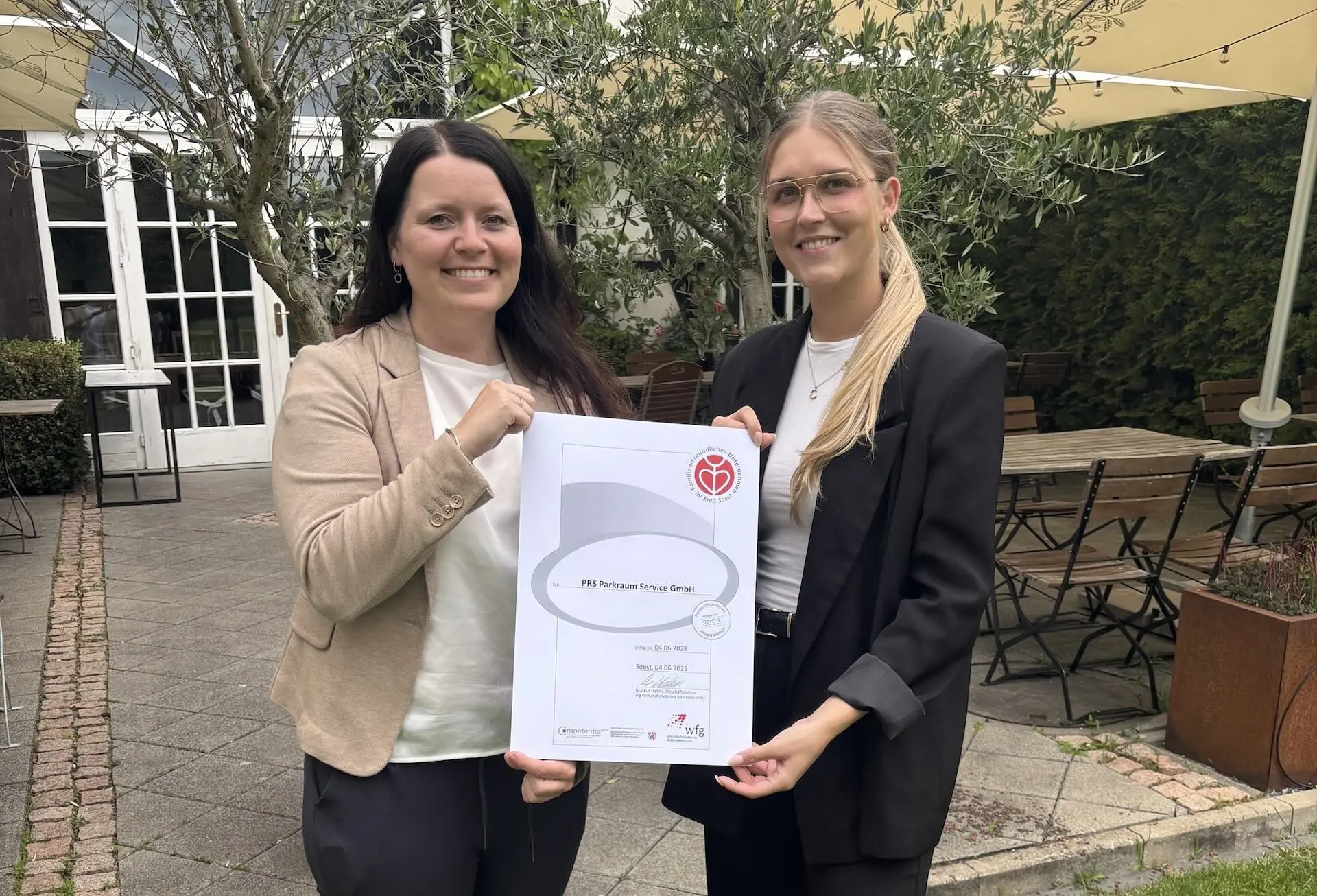 Urkunde zur Zertifizierung als familienfreundliches Unternehmen, präsentiert von Mitarbeiterinnen von PRS